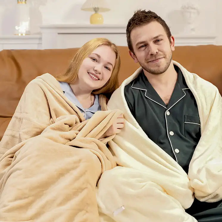 Cream-colored plush blanket draped over a couple on a couch.
