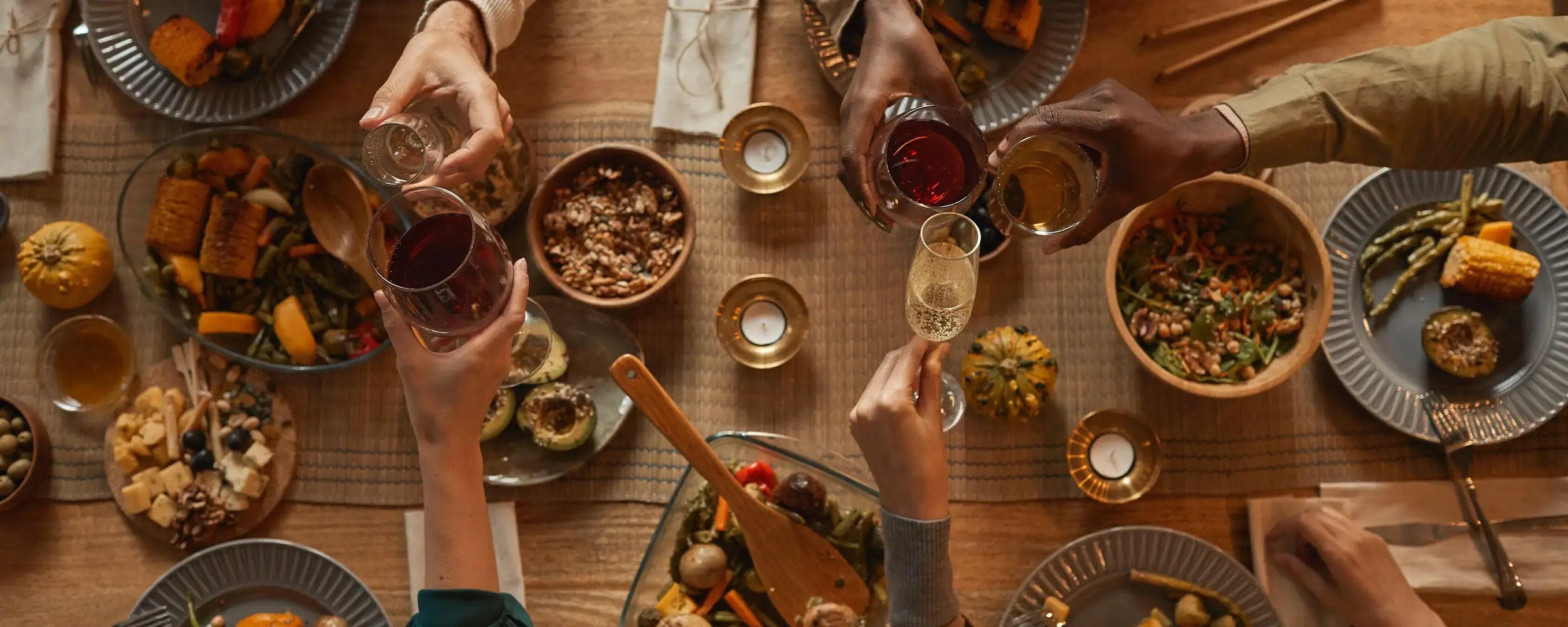 A rustic wooden spoon resting on a vibrant, colorful platter of roasted vegetables and grains.